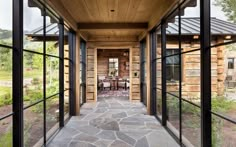 the inside of a house with glass walls and stone walkway leading up to it's front door