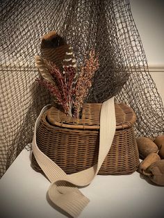 a wicker basket with some dried plants in it