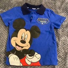 Excellent Condition Mickey Mouse Sz 3t Polo Style Golf Style Top. Adorable Shirt In A Beautiful Bright Blue And With Cute Mickey On One Side And Mickey Mouse Patch On Chest Of The Other Side. All Items Come Washed Unless Nwt Or Nwot. Smoke Free Home. Like It? Make An Offer Or Ask Any Questions. Thank You! Casual Mickey Mouse Tops For Playtime, Cotton Mickey Mouse Tops For Playwear, Cotton Mickey Mouse Top For Playtime, Playful Mickey Mouse Tops For Playtime, Casual Mickey Mouse Tops For Playwear, Golf Style, Baby Mickey Mouse, Embroidered Polo Shirts, Disney Boys