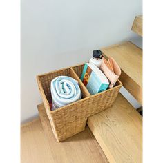 a basket with towels and other items in it on the floor next to some stairs