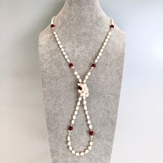 The Return to Origin Jade Beaded Necklace is a versatile and stylish piece of jewelry. It features natural baroque pearls, red carnelian beads, and gold-filled links with wire-wrapped seed pearls. The necklace has a beaded chain that measures 42 inches, and comes with glasses chain connectors, allowing you to wear it in a variety of styles. The set also includes handmade red silk tassels, which can be worn as earrings with gold-plated sterling silver lotus ear wires. This necklace set is the per Elegant Red Pearl Necklace With Natural Stones, Elegant Red Long Necklace, Elegant Long Necklace With Round Natural Stones, Pearl Lariat Necklace, Jade Bead Necklace, Pearl Lariat, Silk Tassels, Red Carnelian, Pearl Necklace Set