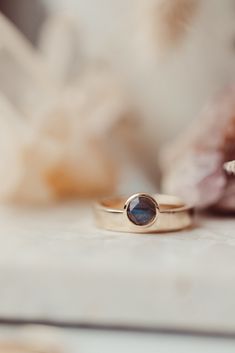 two gold rings sitting on top of a table