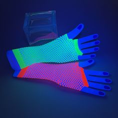 two pairs of neon colored plastic gloves next to a clear container on a blue background