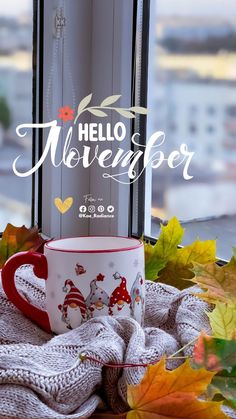 a coffee cup sitting on top of a window sill next to leaves and a blanket