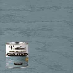 a can of wood stain sitting on top of a wooden floor next to a wall