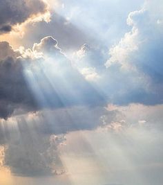 an airplane flying in the sky with sunbeams and clouds