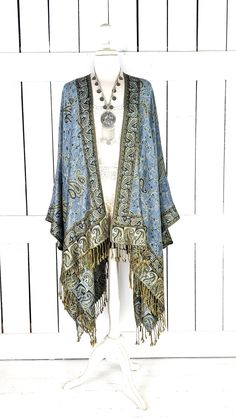 Handmade steel blue and gold paisley pashmina kimono cover up jacket with custom regular and maxi lengths and optional fringe detail Measurements...taken flat - width across seam to seam: 46"  - regular length with fringe: 38"  - regular length without fringe: 34"  - Maxi length is as selected with or without fringe Features... - lovely soft woven medium weigh pashmina fabric - bohemian oversized flowing design - cardigan style with an open front and generous arm holes  - universal design allows a comfortable fit for small through plus sizes - the perfect layering piece that can easily be dressed up or down - wrinkle resistant  - handmade with love by me in California Add a matching attached hood with this link... https://www.etsy.com/listing/1283867624/add-a-matching-hood?click_key=cb563d Bohemian Blue Cape-style Outerwear, Bohemian Blue Cape Outerwear, Bohemian Festival Outerwear With Beaded Fringe, Blue Bohemian Shawl Wrap, Bohemian Kimono With Fringe Shawl, Bohemian Shawl Kimono With Fringe, Bohemian Shawl Cape With Tassels, Blue Bohemian Cape Shawl, Bohemian Shawl With Tassels In Cape Style