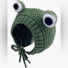 a green knitted hat with two eyes on it