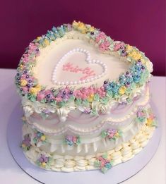 a heart shaped cake with flowers and pearls on it's sides, sitting on a white plate