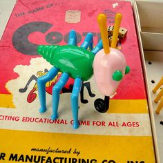 a plastic toy insect sitting on top of a book