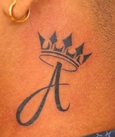 a tattoo on the back of a woman's neck with a crown in it