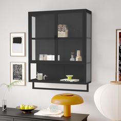 a living room with a black bookcase and yellow accents