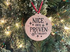 a wooden ornament hanging from a christmas tree with the words nice until proven