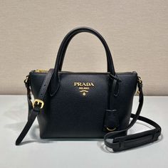 SHOP MORE LUXURY PRODUCTS HERE Description Prada Saffiano Mini Bag Black For Women, Women’s Bags 9.4in/24cm Sophisticated, subtle details bring new life to the brand’s iconic designs like the Prada Double bag with its new versatile and sophisticated mini design. Iconic metallic lettering adorns the front, while a removable shoulder strap allows the bag to be worn over the shoulder or as a crossbody bag. Size: 24 x 19 x 12 cm /9.4 x 7.5 x 4.7 inches (Length x Width x Height) BlackHand Prada Double Bag, Mini Bag Black, Louis Vuitton Shirt, Triangle Bag, Medium Backpack, Prada Saffiano, Handbag Straps, Black Handle, Black Handbags