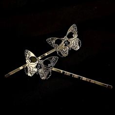 Pieces are attached using a special jewelry adhesive. Please read descriptions thoroughly for sizes and materials.  This is a set of 2 silver hair pins featuring silver metal butterflies with a skull showing in each one. Each one goes in a different direction, so you can wear them on either side of your head, and are mounted on silver hair pins. Pins are 2 3/4" long, and just over  3/4" wide. Make sure to check out my shop for more hair pins, jewelry, accessories, and all sorts of fun stuff! Please note: I am not responsible for any items lost or damaged in the mail. Please double check your address before ordering, and I recommend purchasing insurance. Please note that a special jewelry adhesive is used to adhere the ornament to the pin. It is very sturdy. Black Skull, Set Of Hair Pins, H Silver Hair Pin, Halloween Hair, Black Skulls, Butterfly Hair, Special Jewelry, Silver Hair, Bobby Pins, Hair Pins, Metallic Silver