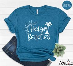 Hola Beaches Cute Beach Shirts For Women, Girls Trip Shirt, Cruise Shirts, Funny Beach Tee, Hola Beaches Shirt, Summer Shirts, Beach Lover  HOW TO ORDER  1-Choose your t-shirt size. 2-Choose your t-shirt color. 3-Type your design color (BLACK or WHITE) 4-Select the quantity, 5- Click Add To Cart. For multiple items go back to the listing and repeat the steps.  CARE INSTRUCTIONS  Wash item inside out in cold water Do not bleach Do not dry clean Do not iron directly on the design. *Please aware th Blue Palm Tree Print Tops For Beach Season, Summer Holiday Graphic Print Tops, Graphic Print Summer Holiday Tops, Summer Holiday Tops With Short Sleeves, Short Sleeve Summer Tops For Holiday, Graphic Print Tops For Summer Holiday, Short Sleeve Tops For Summer Holiday, Vacation Beach Tops With Palm Tree Print, Summer Holiday Shirt With Graphic Print