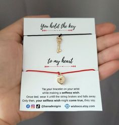 a person is holding a card with a key on it and a red string that says you hold the key to my heart