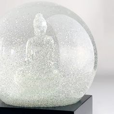 a snow globe sitting on top of a black stand