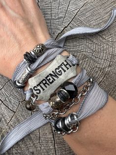 'Strength' - "You were given this life because you were Strong enough to live it"  These bracelets are meant to inspire and empower the wearer!  You can overcome anything!   Silk ribbon with silver chains and glass and crystal bead accents, metal 'STRENGTH' curved tag. Choose your color from the options shown!   Check out more Silk Ribbon Wrap Bracelets here: https://www.etsy.com/shop/gennextjewelry?section_id=18514502&ref=shopsection_leftnav_6 Sizing: All Bracelets are made to fit 7-8" wrists.  If you need something smaller or larger, please mention the length needed when checking out.  I can of course make custom fits.   Guarantee: All my designs are handcrafted with FUN in mind! I love creating pieces thinking about a Fearless Female getting ready to go to a Club, or a Boho Chic Chick r Trendy Jewelry Ideas, Women Survivor, Silk Wrap Bracelets, Ribbon Bracelets, Inspirational Bracelets, Ribbon Wrap, Bride Getting Ready, Silver Chains, Pirate Costume