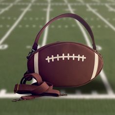 Showcase your love of football when you carry this unique bag! You can even request personalization to show your support for your favorite player or team. Made with vinyl that replicates the feel of a football, this bag is very versatile. You can switch from a top handle to a shoulder/crossbody strap with ease. The back of the football has two small pockets and the interior has one zipper pocket. The purse measures approximately 12" wide x 7" high x 3" deep. This fun purse has a coordinating wal Sporty Rectangular Game Day Bag, Sporty Bags For Football Season, Football Bag, A Football, Unique Bags, Football Mom, Football Season, Handle Bag, College Football