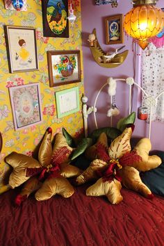 a bed with pillows and pictures on the wall above it, along with other decorations