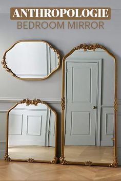 two mirrors sitting next to each other on top of a wooden floor in front of a gray wall