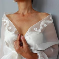 Enhance your bridal ensemble with this stunning ivory-ecru organza shawl stole, adorned with shiny lace trims. The elegant, see-through mesh design drapes effortlessly over the shoulders, offering a romantic touch. Featuring a convenient hands-free loop, the shawl allows for secure styling as the extremity passes through, keeping it perfectly in place. Ideal for brides seeking a lightweight, sophisticated wedding cover-up that blends beauty and practicality. It comes in two length options: Size S: 18.5" x 57.5" (47 x 146 cm) - Suitable for those with an upper body (chest + arms) circumference up to 45.3" (- cm). Size L: 18.5" x 68.5" (47 x 174 cm) - Suitable for those with an upper body (chest + arms) circumference up to 54.3" (- cm)." * As a reference; the model seen at the picture, is in Lace Wedding Shawl, Organza Shawl, Wedding Dress Cover Up, Mesh Wedding Dress, Wedding Dress Cover, Organza Bridal, Bridal Shawl, Sophisticated Wedding, Wedding Shawl