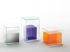 three different colored vases sitting next to each other on a white surface with no one in them