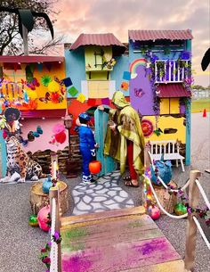 a group of people that are standing in front of some houses with decorations on them