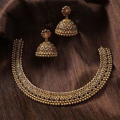 Description This antique necklace set by Tarinika is designed for someone who likes simple Indian jewelry. The necklace is crafted with geometric patterns and CZ stones on an antique gold-plated finish. It comes with traditional Jhumki style earrings which can be worn alone. Style this beautiful CZ patterned necklace set on your favorite ethnic outfit. Details & Specifications: Materials used: Brass Alloy with Antique Plating Weight – Necklace 43 gm, Earrings 25 gm Length – Necklace 12 cm, Earri Elegant Gold Jewelry Sets With Oxidized Finish, Elegant Heavy Brass Temple Necklace, Elegant Antique Gold Chandbali Necklaces, Elegant Brass Temple Necklace With Oxidized Finish, Antique Gold Jewelry With Intricate Design For Celebration, Antique Gold Jewelry For Festive Occasions, Festive Antique Gold Jewelry With Intricate Design, Festive Intricate Antique Gold Jewelry, Elegant Antique Gold Chandbali Temple Necklace