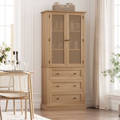 a tall wooden cabinet sitting next to a chair in a living room with white walls