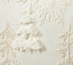 an embroidered christmas tree on white linen