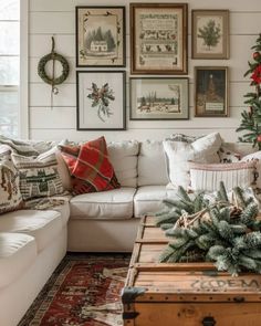 a living room decorated for christmas with pictures on the wall and a tree in the corner