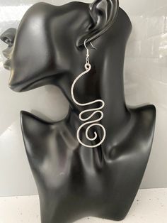 Custom made order. These earrings were designed for a customer following their requirements.  It is also on sale to the public. Hammered aluminium wire dangle earrings.  The swirly design adds a soft and flowy elegance as well as a bold statement.  Wear these statement earrings with confidence and status.  A must wear to compliment any outfit.   The hammered texture to parts of the earrings adds a glimmering beautiful touch.   Contemporary statement aluminium earrings for women.   Sterling silver ear hooks for sensitive earring wearers  The Benefits of Aluminium Jewellery 1. Super light weight 2. It is hypoallergenic due to not containing Nickel  3. It doesn't rust 4. It doesn't tarnish 5.  Easy to clean, if needed wash in soapy water A stunning pair of geometric earrings! Silver Dangle Wire Earrings, Silver Spiral Earrings For Party, Elegant Swirl Wire Wrapped Earrings, Minimalist Silver Swirl Earrings, Metal Spiral Earrings With Ear Wire, Spiral Metal Earrings With Ear Wire, Silver Plated Wire Dangle Earrings, Silver Wire Dangle Wrap Earrings, Silver Wire Wrap Dangle Earrings