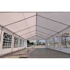 a large white tent is set up on the side of a building with windows and doors