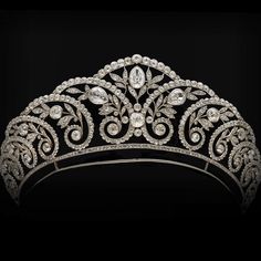 a tiara with an intricate design on the front and sides, set against a black background