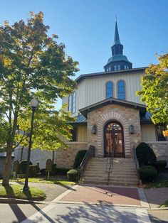 an old church with a steeple on the top and stairs leading up to it