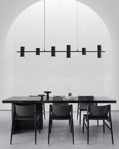 a black and white photo of a dining table with four chairs in front of it