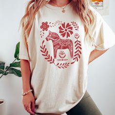 Get ready to be OBSESSED with your new Scandinavian Christmas Crewneck shirt. It's the cutest and most trendy way to combine all those important trendy Hygee vibes! This is the perfect Swedish holiday shirt!  * Q U I C K * F A C T S * ✺  All shirts are UNISEX ✺  100%  ringspun cotton (fiber content may vary for different colors) ✺  Soft-washed, garment-dyed fabric brings extra coziness ✺  Wash and dry normally (on cool for best results) ✺  Sewn-in twill label * S I Z I N G * ✺ For an oversized fit, select two or three sizes up from your normal size ✺ Model is wearing size L  ✺ Sizing runs true to size ✺ Relaxed fit ✺ Most women find their typical size works best, since they are meant to fit a touch loose ✺ See Size guide and fit in images          * S H I P P I N G * T I M E S * ✺ Our item Festive Cotton Graphic Print T-shirt, Festive Cotton T-shirt With Graphic Print, Festive Cotton Tops With Graphic Print, Holiday Cotton Tops With Relaxed Fit, Holiday Cotton Graphic Tee Shirt, Cotton Graphic Tee Shirt For Holidays, Festive Casual Cotton Tops, Festive Short Sleeve Cotton Tops, Red Screen Print Tops As Gift