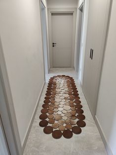 a long hallway with several plates on the floor in front of an open door that leads to another room