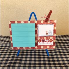 a paper bag with a note attached to it sitting on top of a checkered table cloth