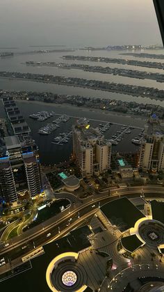 an aerial view of a city at night with boats in the water and lights on