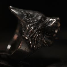 Blank eyes, bare silver teeth and a hyper aggressive expression.  You can almost hear the deep growl and see the drool running from the mouth of this very realistic Sterling Silver Wolf Beast Ring. This ring is finished in a beautiful combination of blackened oxidation with a contrasting highpolished surface of the eyes and teeth. The inside has the Book of Alchemy crest sculpted in embraced by Gothic ornamental details. The weight is 59 grams (based on a size 64) and measures 36.3mm from top to Blank Eyes, Wolf Beast, Silver Teeth, Mens Skull Rings, Fire Jewelry, Silver Wolf, Premium Packaging, Star Ring, Skull Ring