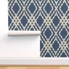 a blue and white wallpaper with an intricate design on it's side, next to a wooden floor