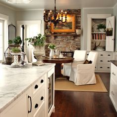 a large kitchen with white cabinets and marble counter tops, along with an island in the middle