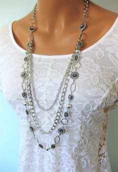 "Long Silver Chain Beaded Necklace, handmade by Ralston Originals. This long beaded necklace is made with different sizes and shapes of silver metal beads, rings, and filigree.  There are 2 additional strands of silver metal chain, making the necklace 3 multi strands. The multi strands are attached to a large silver metal ring. The necklace has a lobster clasp. This beaded necklace is 40 inches long, but can be made shorter on request. This necklace is ready to send today. I carefully package it Silver Metal Beaded Necklaces With Round Beads, Silver Beaded Necklaces With Round Beads, Elegant Silver Metal Bead Jewelry, Elegant Silver Metal Beads Jewelry, Elegant Silver Beaded Necklace, Multi-strand Metal Jewelry With Silver Beads, Silver Multi-strand Beaded Chain Necklace, Multi-strand Silver Beads Jewelry, Silver Beads Multi-strand Jewelry