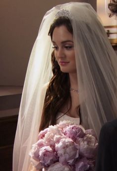 a woman in a wedding dress holding a bouquet of flowers