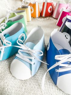 several pairs of colorful shoes tied to each other on a white bed with the colors of rainbow and blue