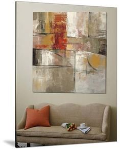 an abstract painting hangs on the wall above a couch