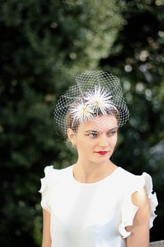 a woman wearing a white dress with a birdcage on it's head